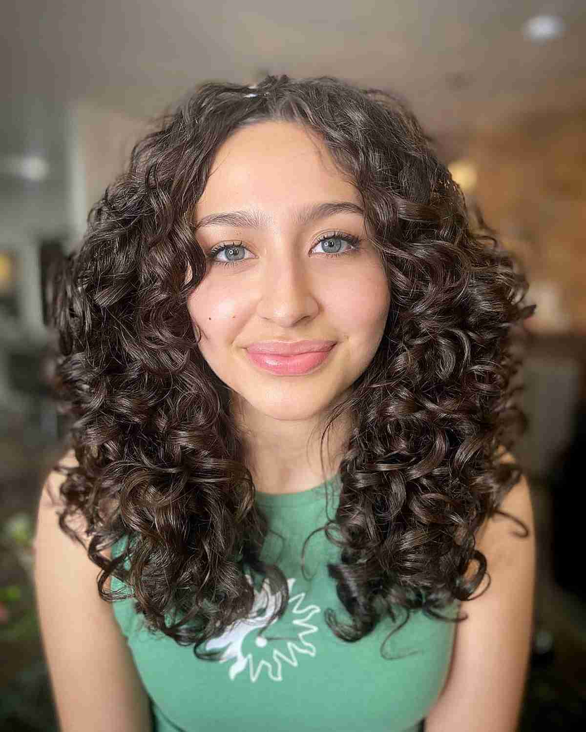 Slimming Center Parted Medium Hair with Layered Curls for Round Faces