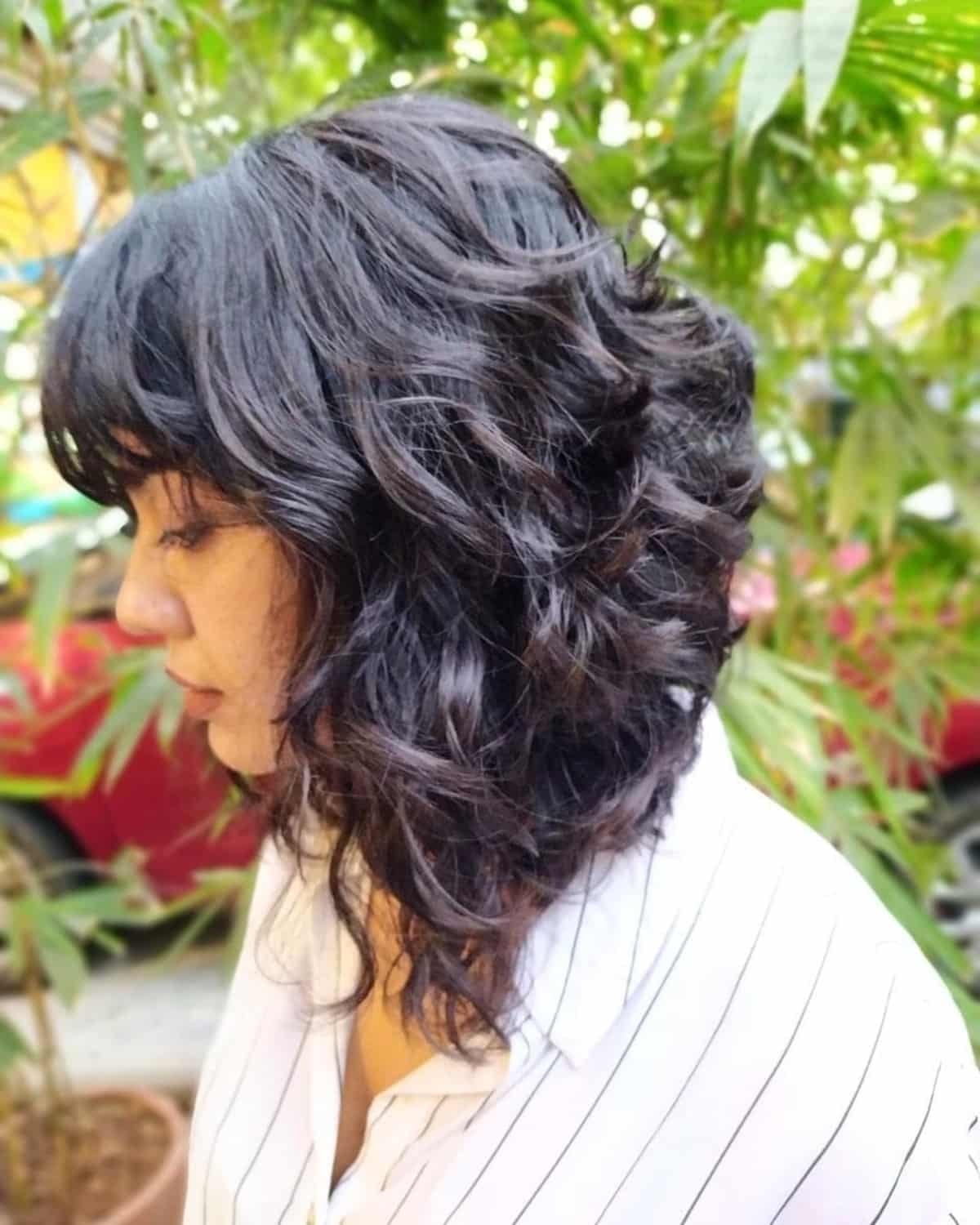 Mid-length angled bob with bangs for curly hair